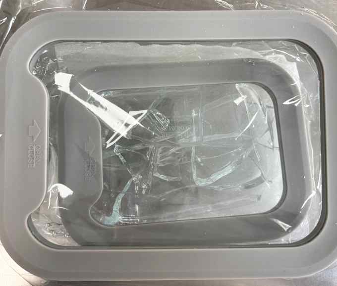 A glass container with shuttered pieces of another glass container inside. 